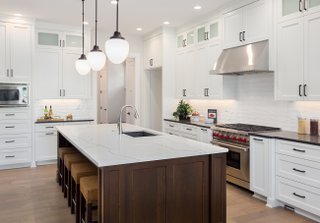 beautiful-kitchen-in-new-luxury-home-with-large-island -pendant-lights -oven -range -and-hardwood-floors.-697394012_4000x2794.jpeg